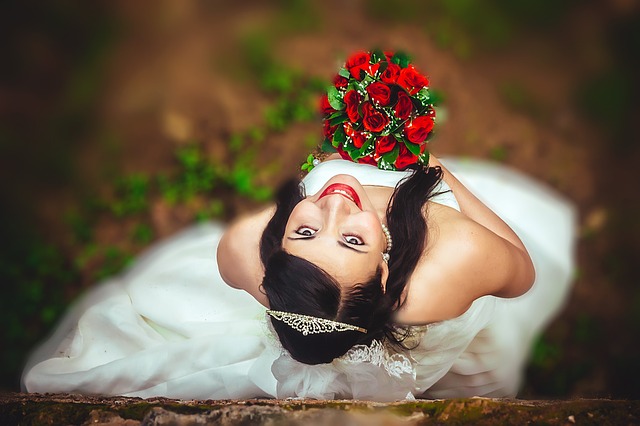nevěsta černovláska s kyticí rudých růží