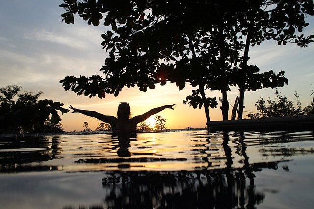 dívka v bazénu při západu slunce